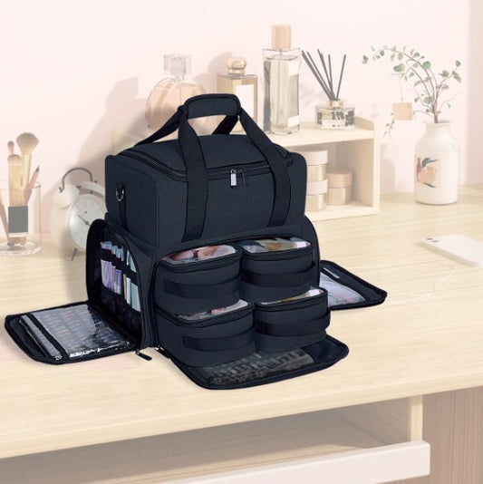 Une **malette maquillage** noire professionnelle, ouverte sur un bureau en bois clair, révélant ses nombreux compartiments de rangement organisés et ses tiroirs modulables.