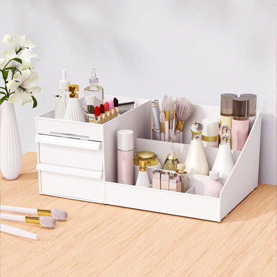 Un organisateur de maquillage blanc et moderne rempli de divers produits de beauté. L'organisateur est divisé en plusieurs compartiments de différentes tailles et profondeurs, conçus pour accueillir une variété d'articles tels que des rouges à lèvres, des pinceaux, des lotions et des parfums. Il comporte également deux tiroirs coulissants pour un rangement plus discret.