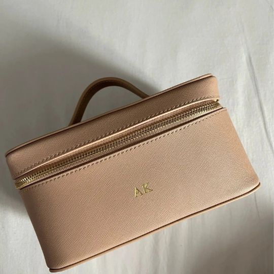 Trousse de maquillage rose poudré élégante, fermeture éclair dorée, initiales AK.