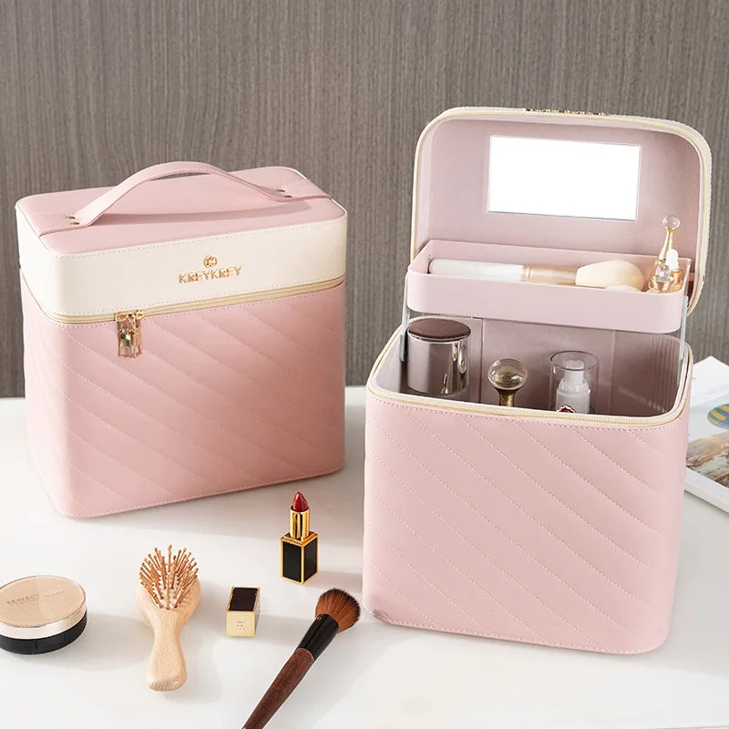 Une mallette maquillage rose et blanche ouverte révèle des compartiments organisés, entourée de produits de beauté sur une table lumineuse.